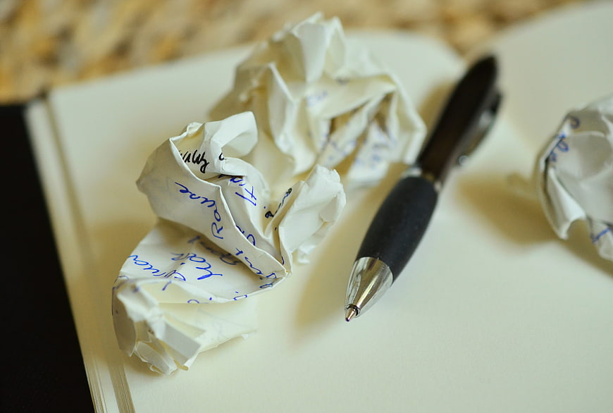 Crumpled paper balls and pen on notebook page