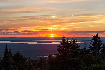 Vibrant Sunset Over Lake and Forest Landscape