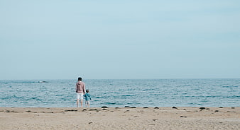 Father and Son Holding Hands Looking at Ocean Horizon