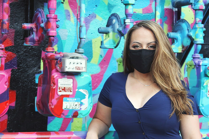 Woman in Black Mask Against Colorful Graffiti Wall