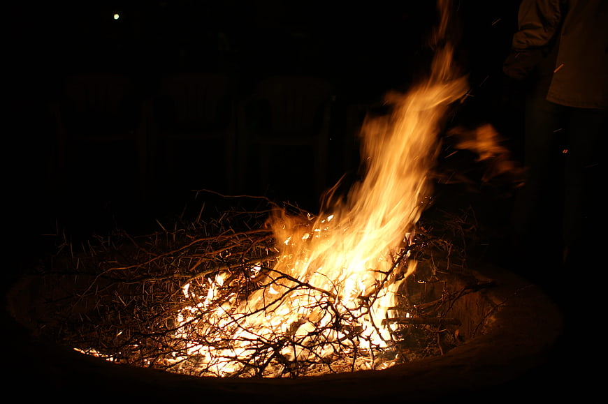 Campfire burning at night with bright orange flames