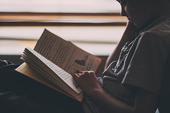 Child Reading Book in Dimly Lit Room