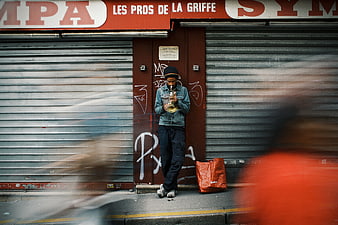 Street musician playing saxophone in front of closed shop