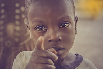 Close-up portrait of young African boy pointing finger