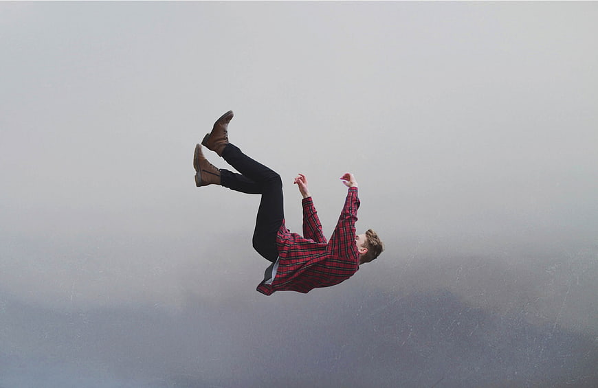 Man falling through foggy sky in red plaid shirt