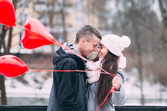 Happy Winter Couple with Red Heart Balloons