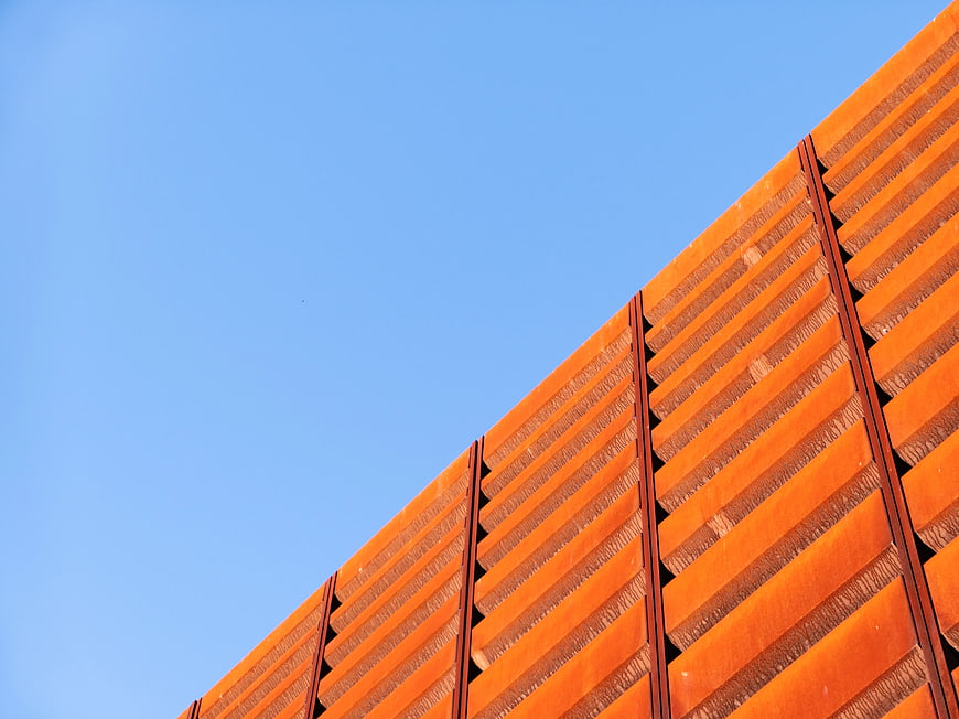 Abstract Orange Louvered Building Facade Against Blue Sky