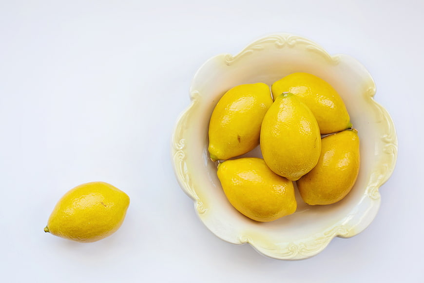 Fresh Yellow Lemons In White Ceramic Bowl On White Background
