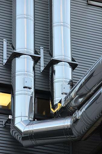 Shiny Metal Ventilation Ducts on Industrial Building Exterior