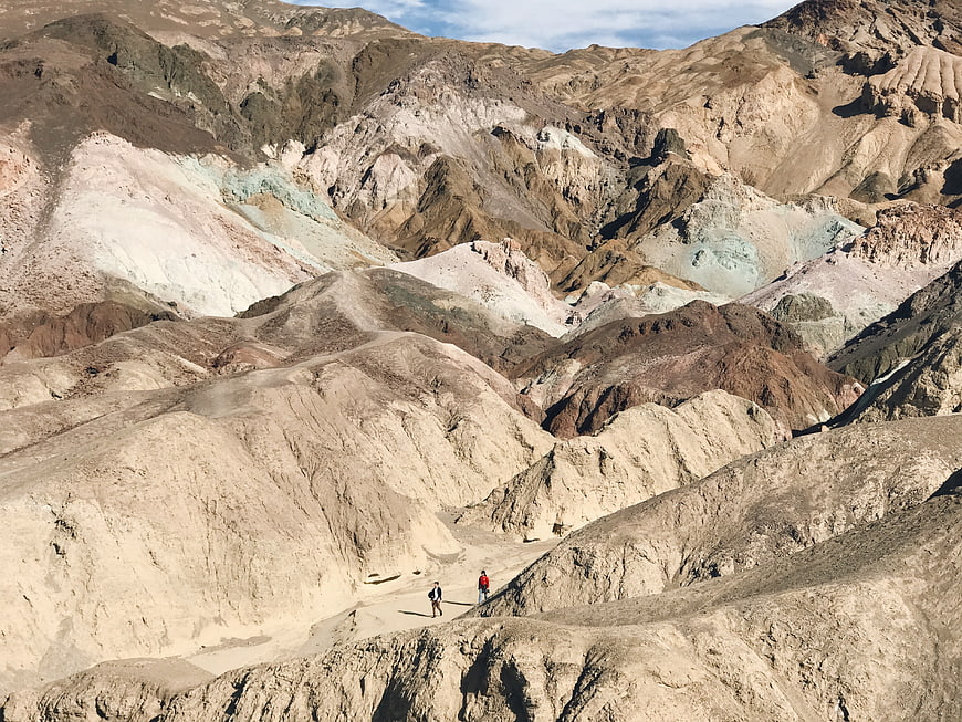 Hikers walking through colorful desert mountains