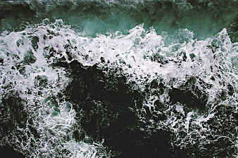 Aerial view of crashing ocean waves with white foam