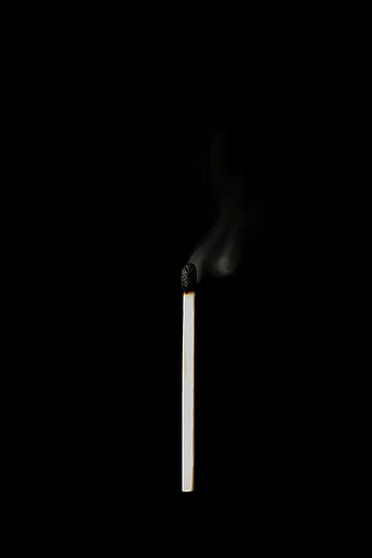 Single Burning Matchstick with Smoke on Black Background