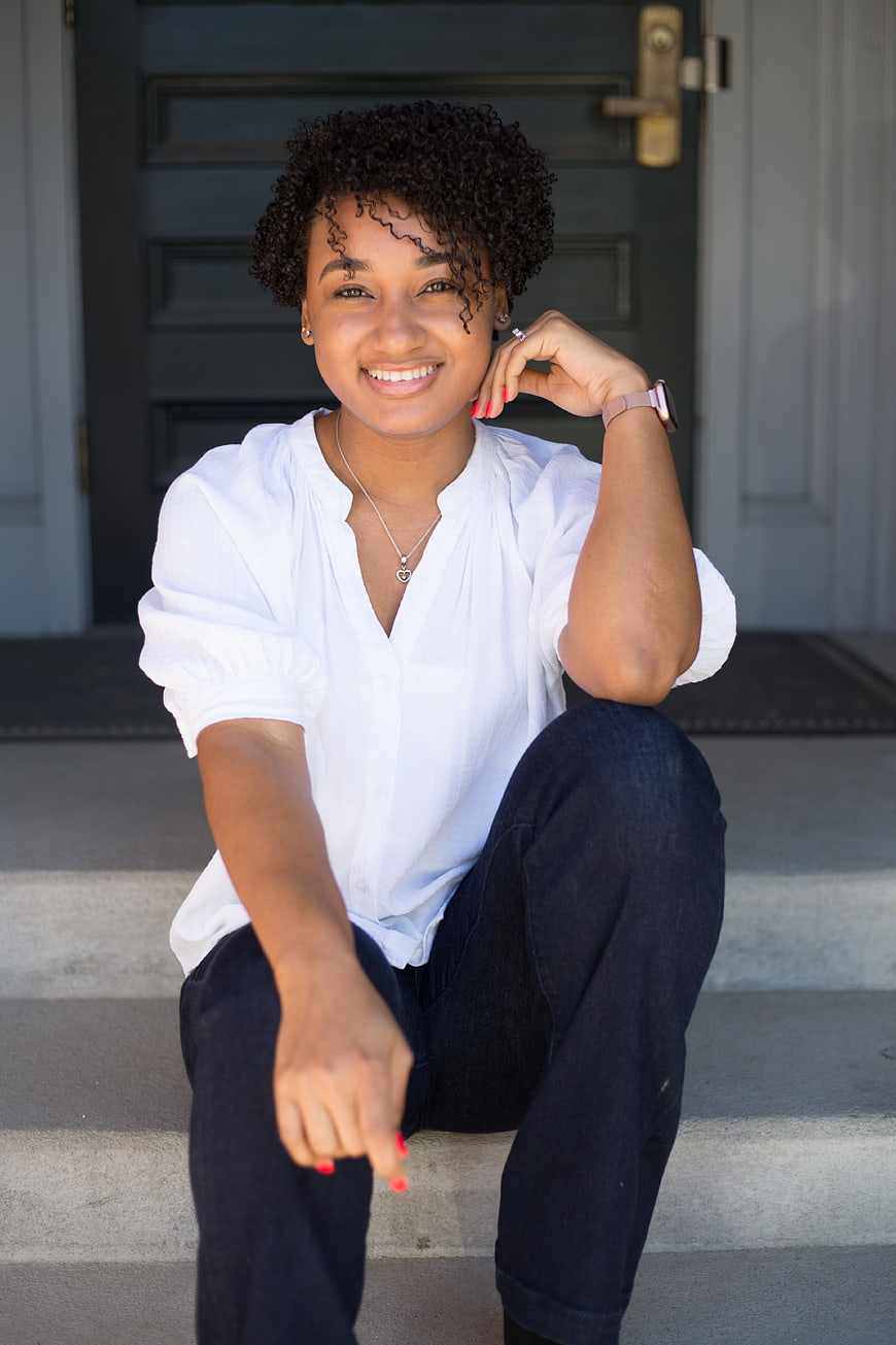 Smiling young woman sitting on outdoor steps