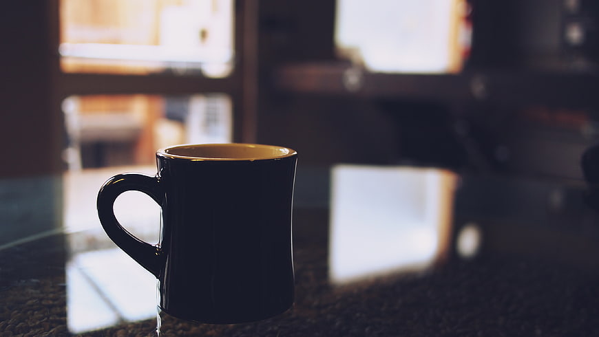 Black Coffee Mug on Granite Countertop with Blurred Background