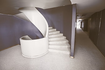 Modern white spiral staircase in minimalist interior hallway