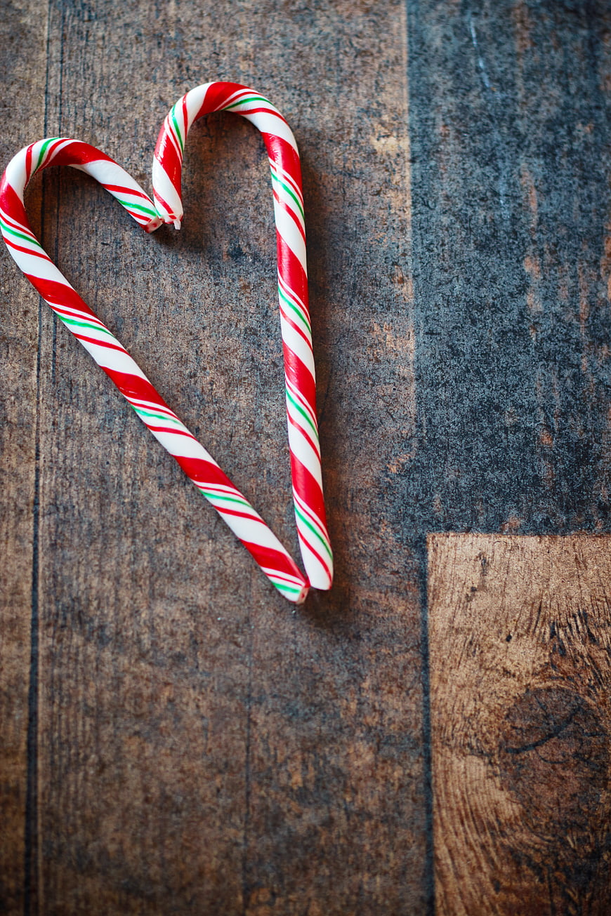 Candy Canes Forming Heart Shape on Rustic Wood
