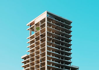 Unfinished Concrete High-Rise Building Against Blue Sky
