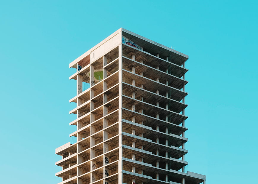 Unfinished Concrete High-Rise Building Against Blue Sky