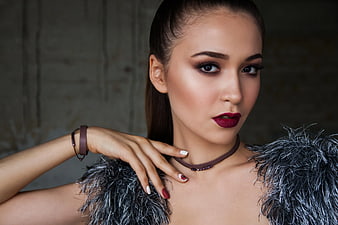Portrait of Woman with Dark Makeup and Feathered Top