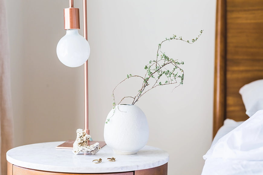 Minimalist Bedroom Nightstand with Copper Lamp and White Vase