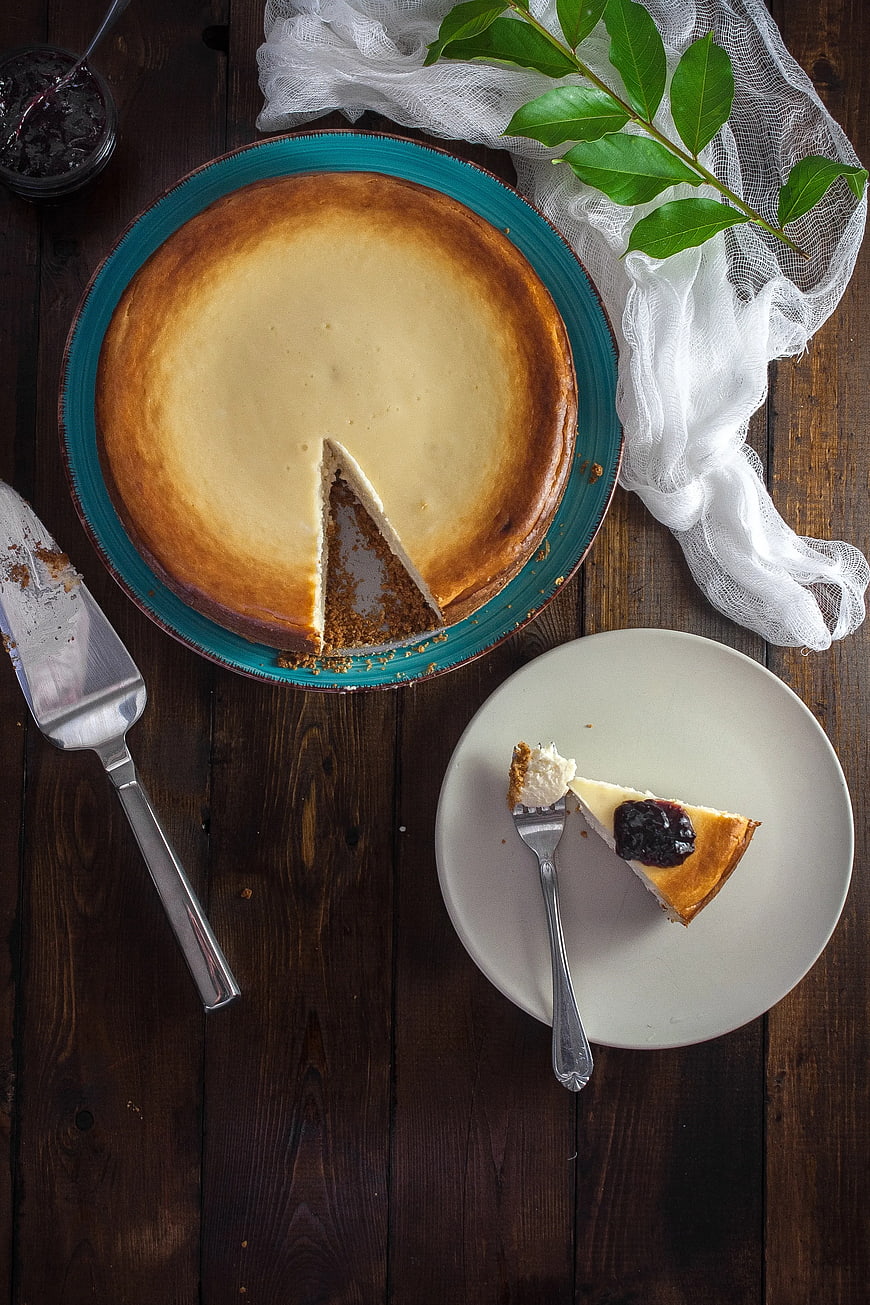 Overhead view of cheesecake with berry topping on rustic wood