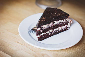 Slice of layered chocolate cake on white plate