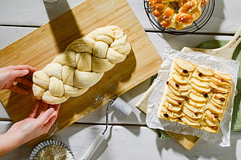 Top view of braided yeast dough and apple tart baking