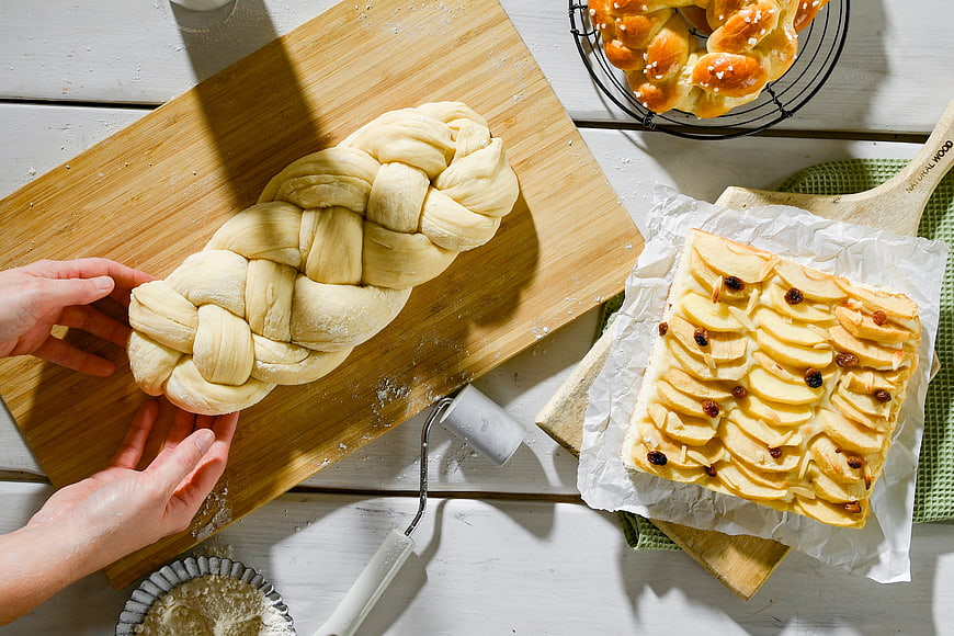 Top view of braided yeast dough and apple tart baking