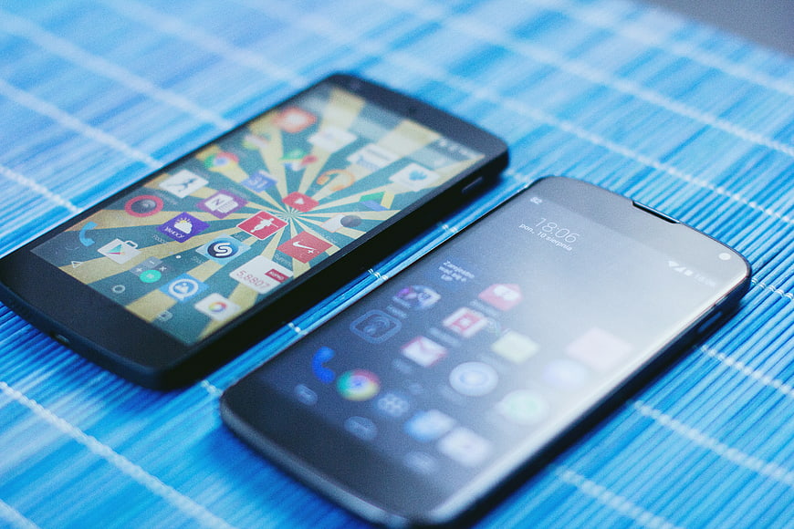 Two smartphones on blue bamboo mat background