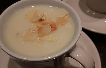 Creamy cauliflower soup with almond slices in white cup