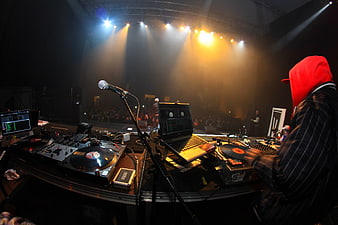 DJ performing at a live concert with turntables and laptops