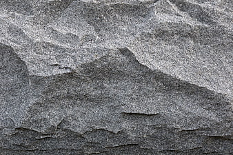 Close-up texture of rough grey granite rock surface