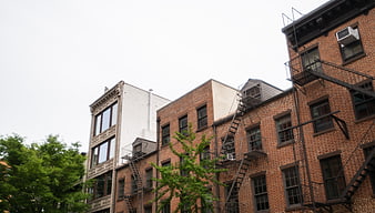Low angle view of urban brick apartment buildings with fire escapes