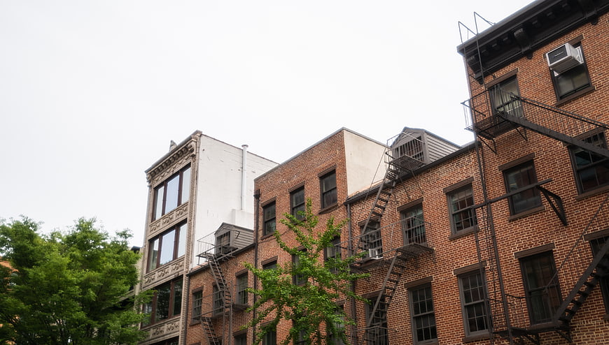 Low angle view of urban brick apartment buildings with fire escapes