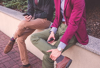 Two Men in Smart Casual Fashion Sitting on a Wall