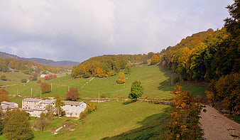 Autumnal Italian countryside landscape with rolling green hills and village
