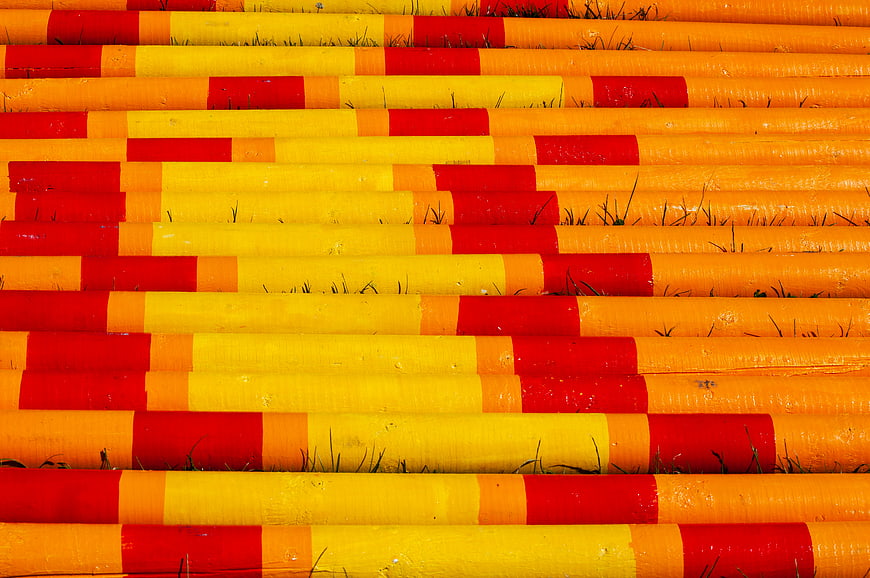 Colorful striped horse jump poles on grass