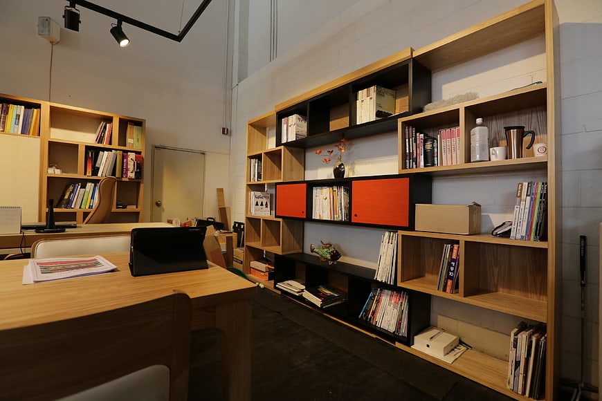 Modern office interior with wooden bookshelves and desk
