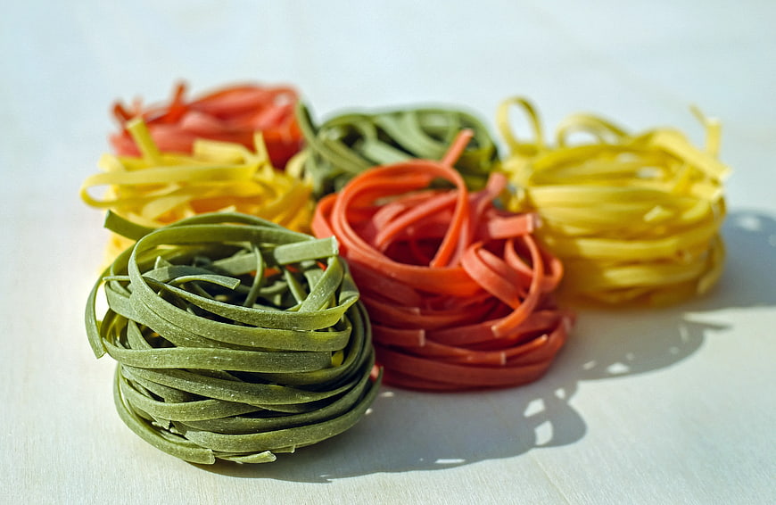 Colorful nests of fresh green, red, and yellow pasta