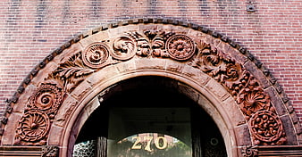 Ornate Stone Archway on Red Brick Building Exterior