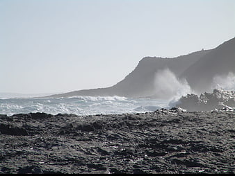 Rough Ocean Waves Crashing Against Rocky Coastal Shoreline