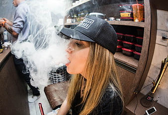 Woman exhaling smoke in a lounge setting