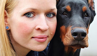 Close-up portrait of a woman with a Doberman Pinscher dog