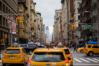 Yellow taxis driving down a busy New York City street