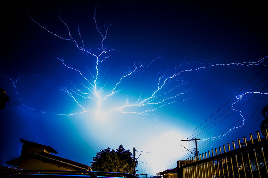 Dramatic Blue Lightning Strike Over Residential Neighborhood at Night