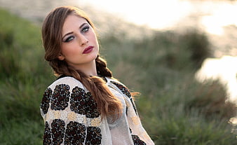 Portrait of woman in traditional embroidered shawl by lake