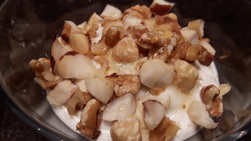 Close-up of quark yogurt topped with hazelnuts and honey