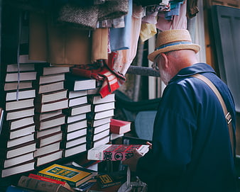 Senior man browsing books at a vintage market stall