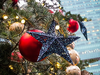 Close-up of Glittery Blue Star Ornament on Christmas Tree