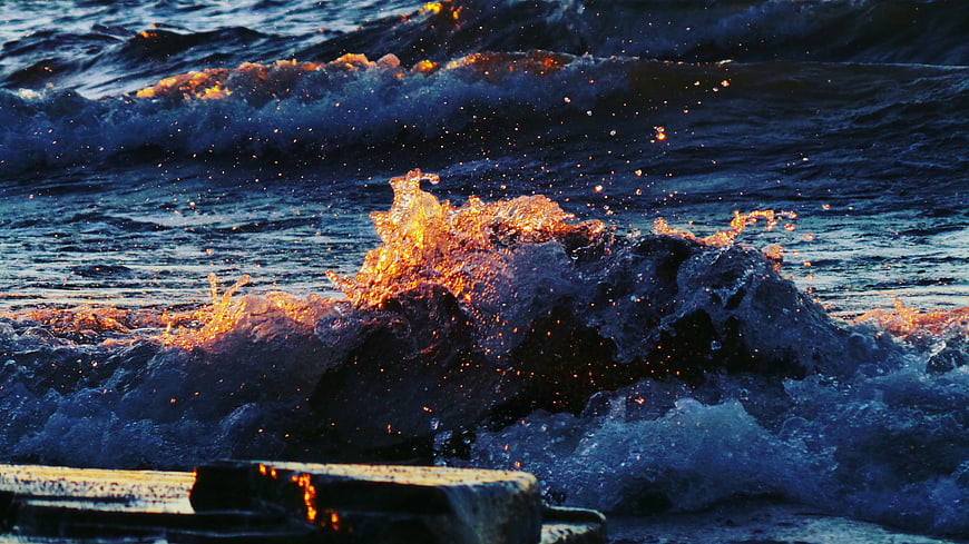 Dramatic Ocean Waves Crashing at Sunset with Golden Light